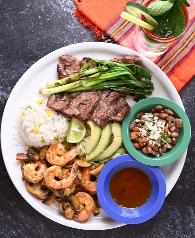 Sizzling steak and shrimp fajita platter with rice, beans, and salsa at Casa Vallarta